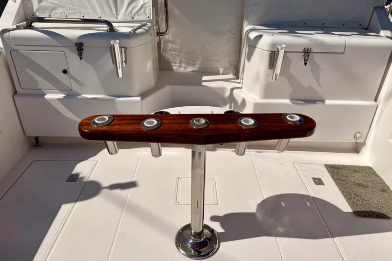 Slide: The Image of 2001 Cabo 35 Express boat cockpit with rod holders and storage compartments. - 37