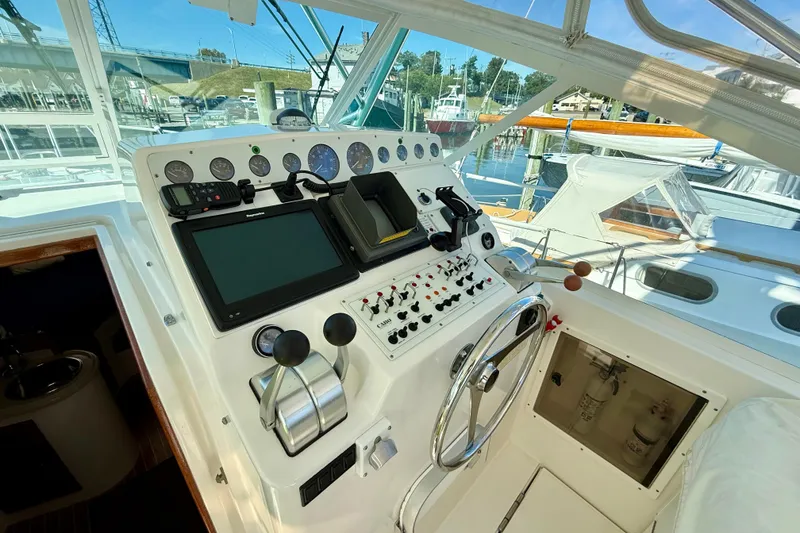 Slide: The Image of Control panel of a 2001 Cabo 35 Express boat, featuring navigation instruments and steering wheel. - 43