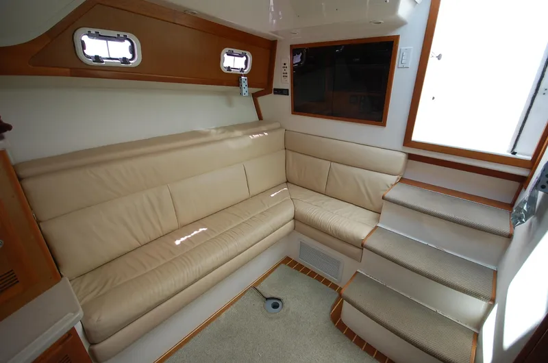 Slide: The Image of Interior of 2001 Cabo 35 Express yacht with beige seating and carpeted stairs. - 5