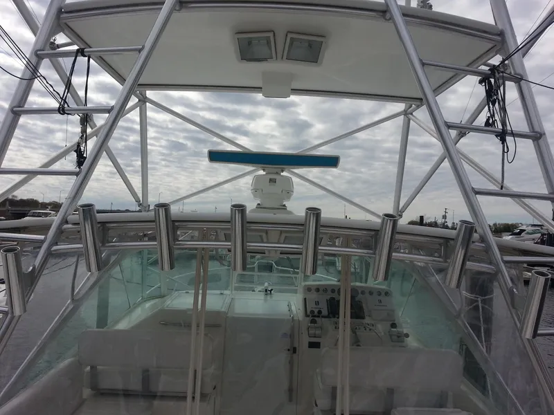 Slide: The Image of Helm of 2001 Cabo 35 Express boat with fishing rod holders and navigation equipment. - 7
