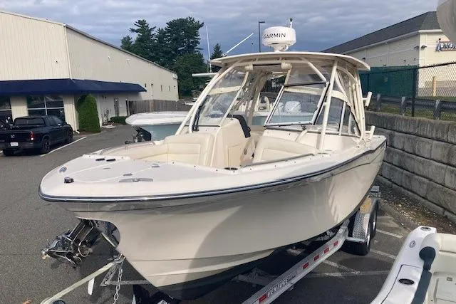 Slide: The Image of 2022 Grady-White Freedom 275 boat on trailer, parked outdoors near buildings. - 2