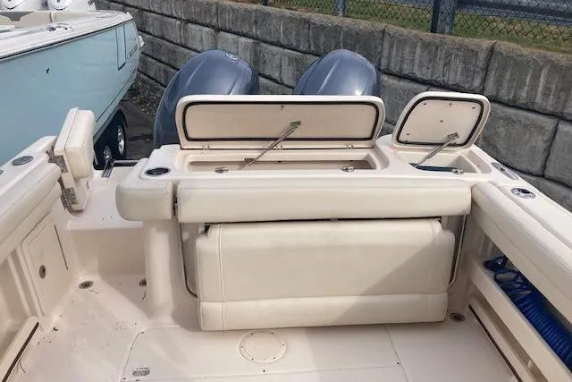 Slide: The Image of 2022 Grady-White Freedom 275 boat interior with storage compartments and dual engines. - 5