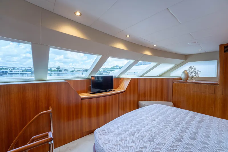Slide: The Image of Luxurious 2016 Horizon PC60 yacht bedroom with panoramic windows and elegant wood paneling. - 18