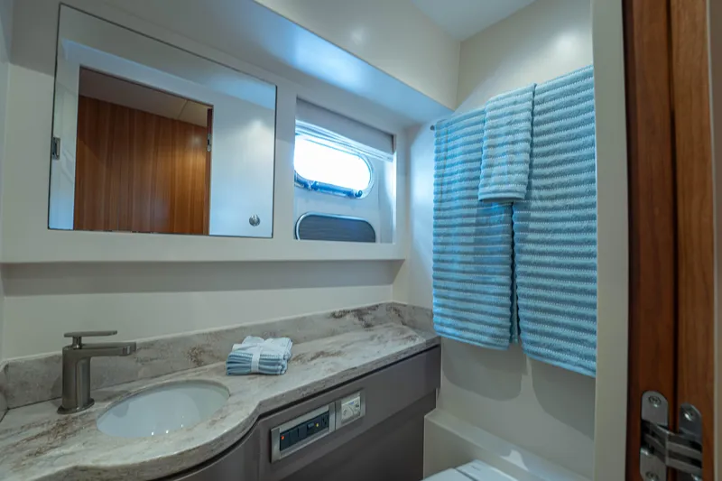 Slide: The Image of Luxurious bathroom in 2016 Horizon PC60 yacht with modern fixtures and striped towels. - 29