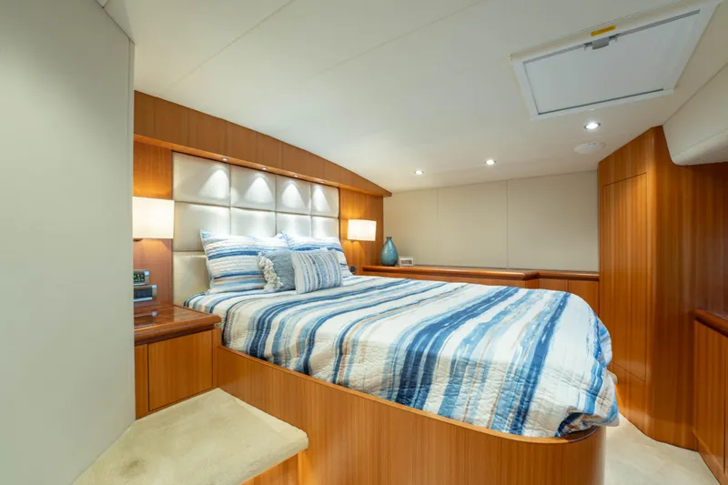 Slide: The Image of Luxurious bedroom interior on 2016 Horizon PC60 yacht with striped bedding and wood paneling. - 31