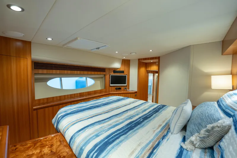 Slide: The Image of Luxurious bedroom interior of 2016 Horizon PC60 yacht with wood paneling and striped bedding. - 33