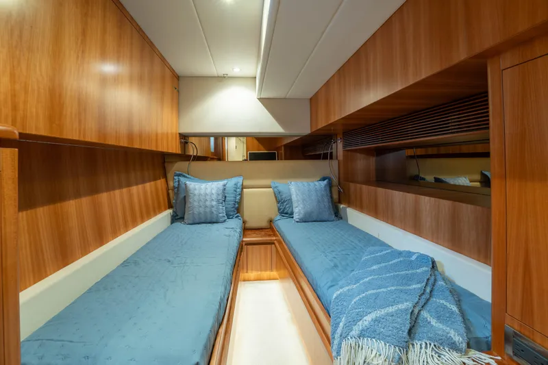 Slide: The Image of Luxurious twin cabin interior on 2016 Horizon PC60 yacht with wooden finish and blue bedding. - 35
