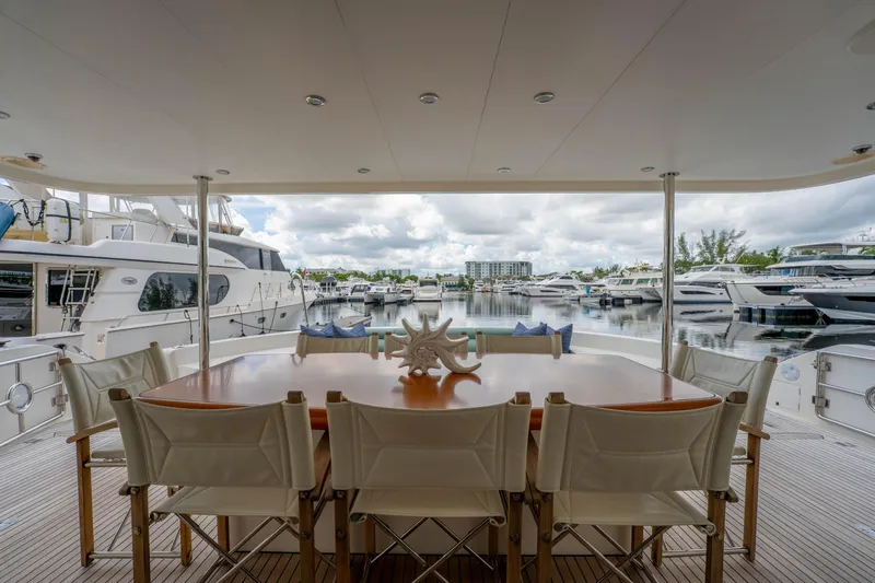 Slide: The Image of Luxury yacht deck with dining area, Horizon PC60, 2016, overlooking marina with multiple boats. - 45