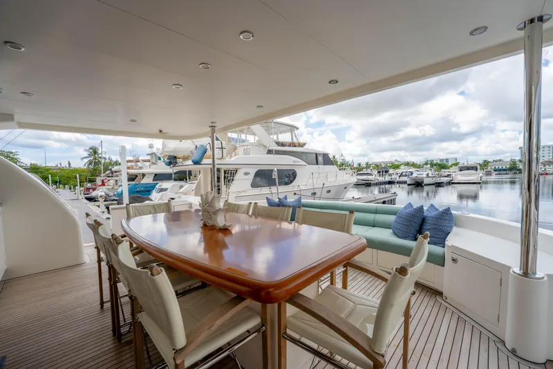Slide: The Image of Luxurious 2016 Horizon PC60 yacht deck with dining area, marina view, and comfortable seating. - 46