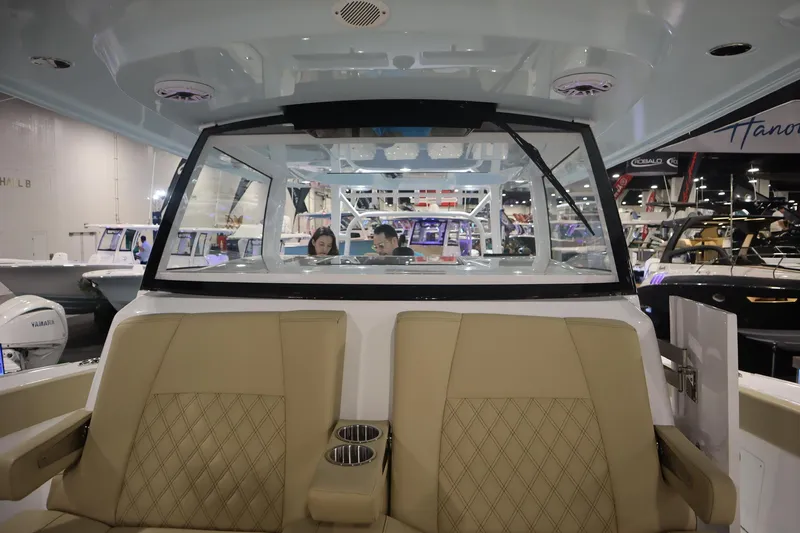Slide: The Image of 2026 Sportsman Open 402 Center Console interior at a boat show, featuring tan seating. - 12