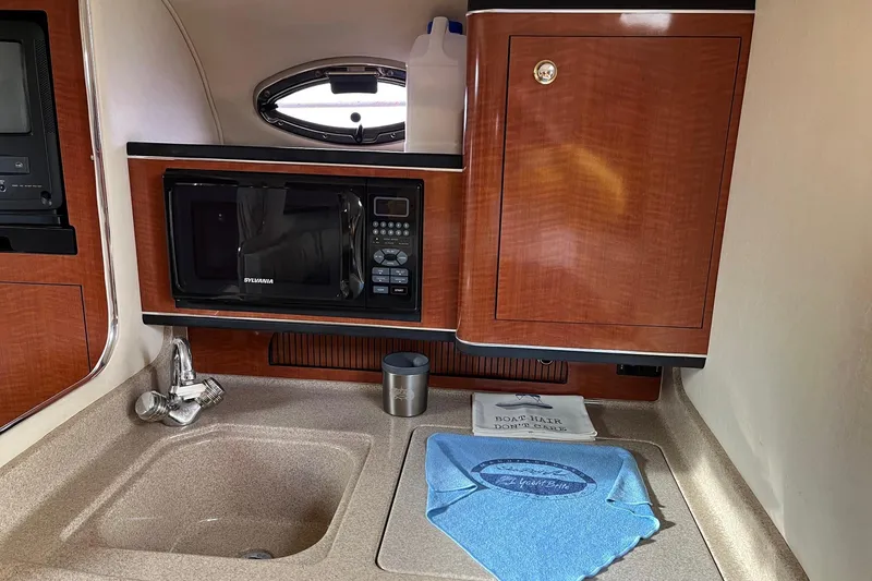 Slide: The Image of Interior of 2003 Sea Ray 280 Sundancer with cozy seating and elegant wood cabinetry. - 14