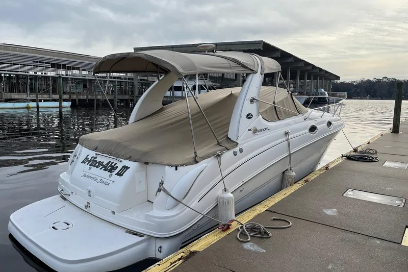 Slide: The Image of 2003 Sea Ray 280 Sundancer galley with microwave, sink, and wooden cabinetry. - 16