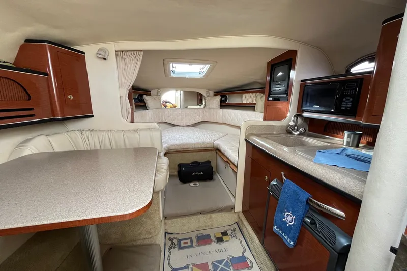Slide: The Image of 2003 Sea Ray 280 Sundancer bathroom with sink, toilet, and porthole window. - 26