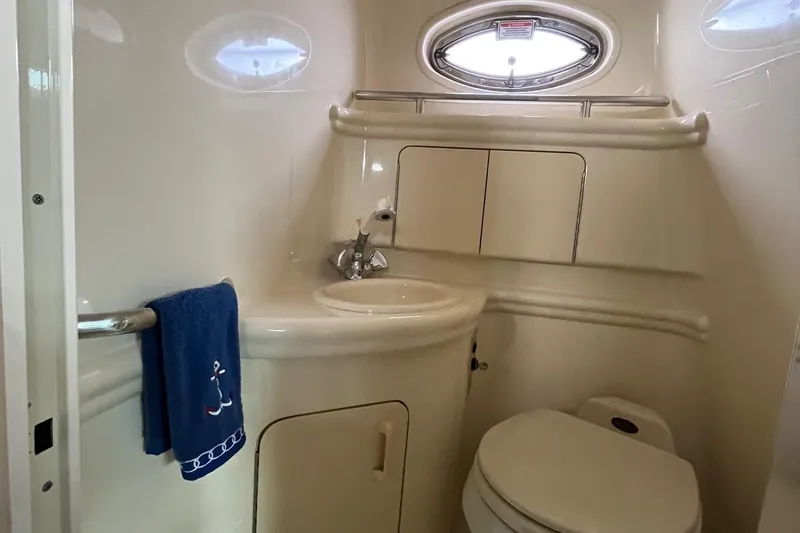 Slide: The Image of Interior view of 2003 Sea Ray 280 Sundancer boat with white seating and open water backdrop. - 27