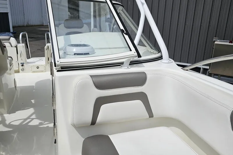 Slide: The Image of 2018 WorldCat 255 DC boat interior with white and gray seating, windshield, and railing. - 12