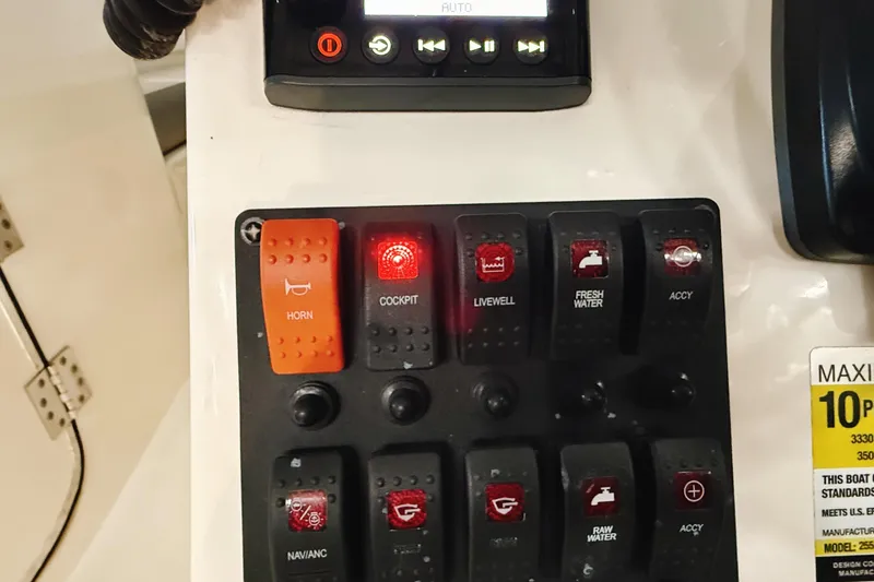 Slide: The Image of Control panel of a 2018 WorldCat 255 DC boat with labeled switches and buttons. - 19