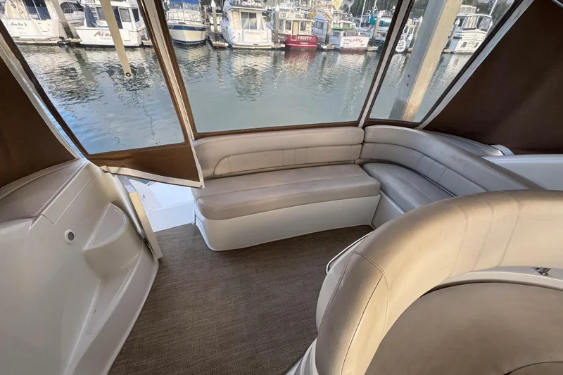 Slide: The Image of 2002 Regal Commodore 3860 yacht interior with beige seating and marina view. - 15