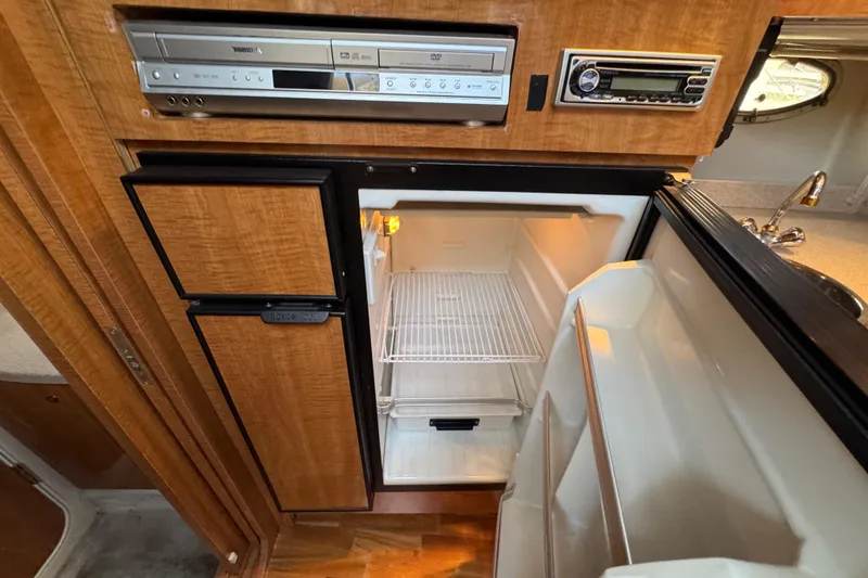 Slide: The Image of 2002 Regal Commodore 3860 yacht kitchen with open fridge and built-in appliances. - 33