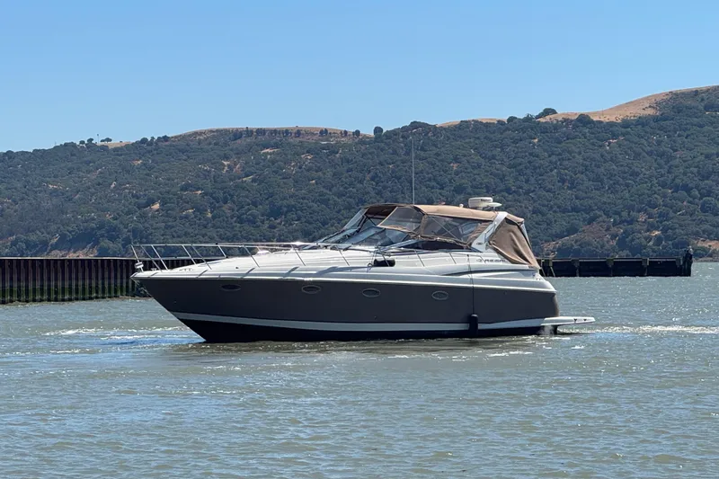 Slide: The Image of 2002 Regal Commodore 3860 yacht cruising on a scenic lake with hills in the background. - 7