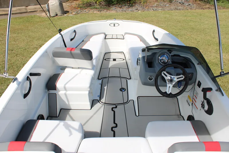 Slide: The Image of 2021 Tahoe T16 boat interior with modern steering and seating on grass. - 11