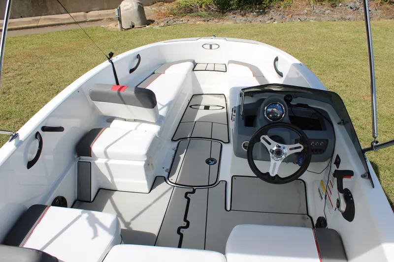 Slide: The Image of 2021 Tahoe T16 boat interior with steering wheel and seating on grass. - 13