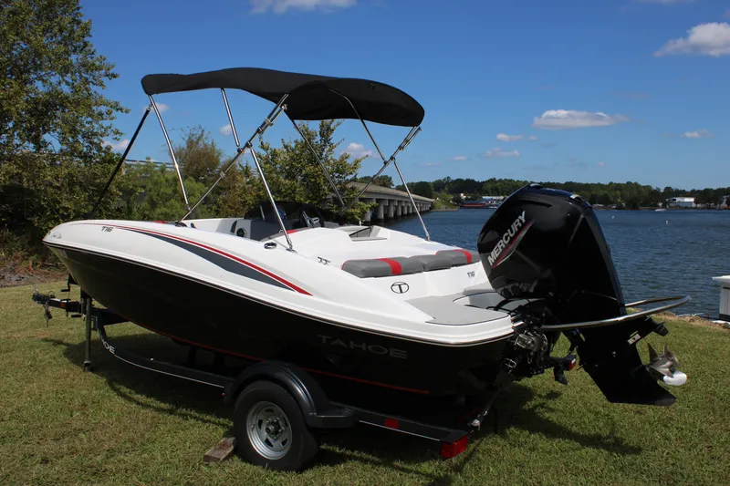 Slide: The Image of 2021 Tahoe T16 boat with Mercury engine by a lake under a clear blue sky. - 17