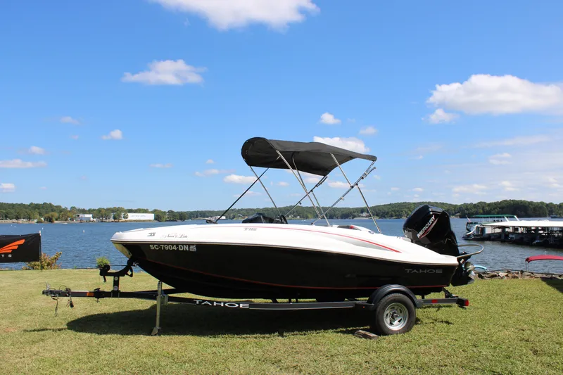 Slide: The Image of 2021 Tahoe T16 boat on trailer by a scenic lake under blue sky. - 3