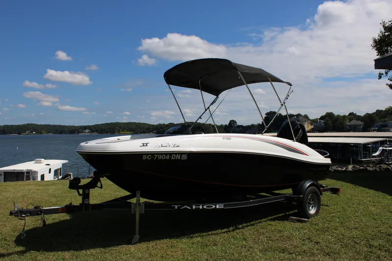 Slide: The Image of 2021 Tahoe T16 boat on trailer by a scenic lake under a blue sky. - 4