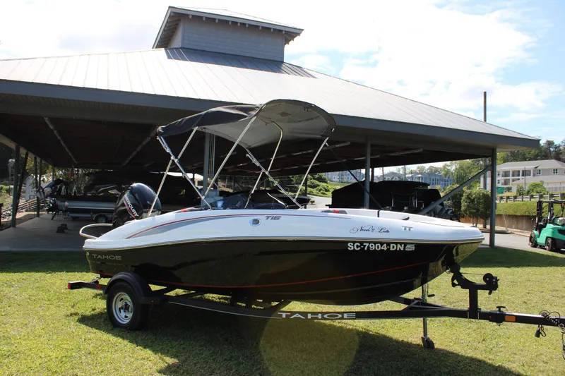 Slide: The Image of 2021 Tahoe T16 boat on trailer under a metal canopy, parked on grass. - 5