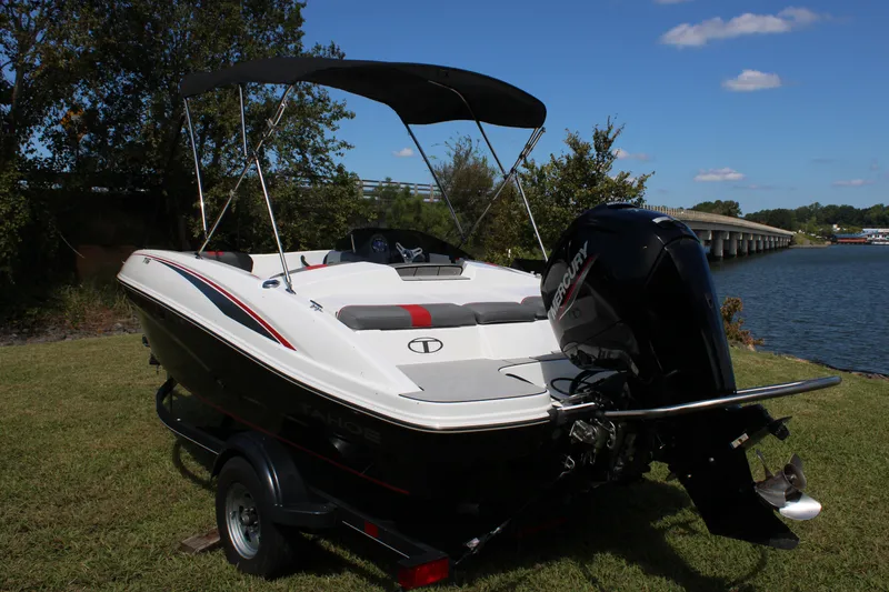 Slide: The Image of 2021 Tahoe T16 boat with Mercury engine, parked on grass by a lake under a clear sky. - 6