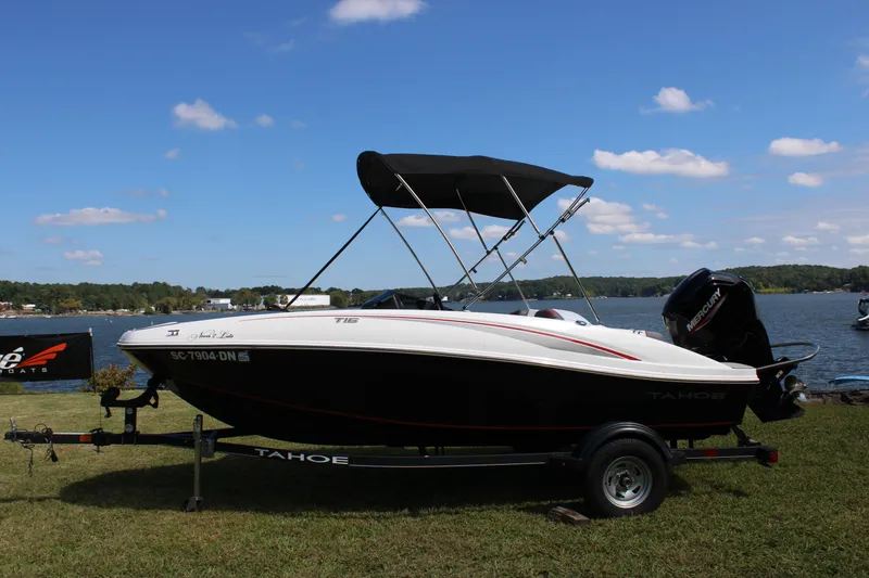 Slide: The Image of 2021 Tahoe T16 boat on trailer by a lake under a clear blue sky. - 8
