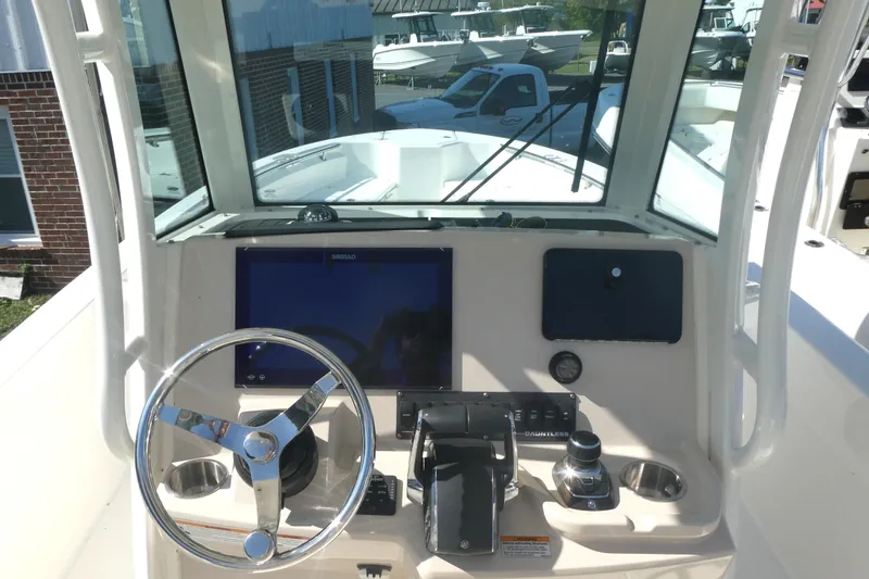 Slide: The Image of 2023 Boston Whaler 280 Dauntless helm with steering wheel and navigation display. - 11