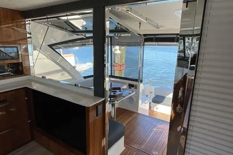 Slide: The Image of Interior view of 2025 Riviera 585 SUV yacht, featuring modern design and waterfront backdrop. - 12