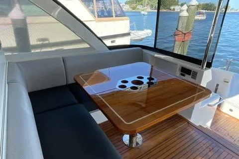 Slide: The Image of Luxurious 2025 Riviera 585 SUV yacht interior with elegant wooden table and waterfront view. - 15
