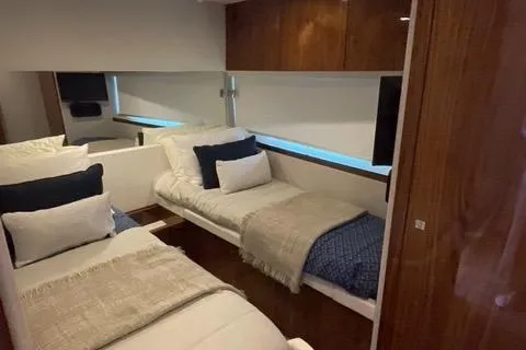 Slide: The Image of Interior of 2025 Riviera 585 SUV yacht with twin beds and modern decor. - 21