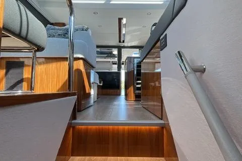 Slide: The Image of Interior view of 2025 Riviera 585 SUV yacht, featuring modern design and wood accents. - 23