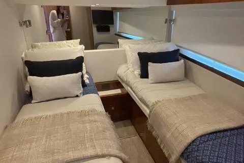 Slide: The Image of Interior of 2025 Riviera 585 SUV yacht with twin beds and modern decor. - 24