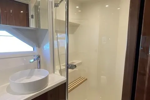 Slide: The Image of Luxurious bathroom in 2025 Riviera 585 SUV yacht with modern fixtures and elegant design. - 25