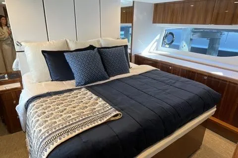 Slide: The Image of Luxurious bedroom interior of 2025 Riviera 585 SUV yacht with elegant bedding and wood accents. - 27