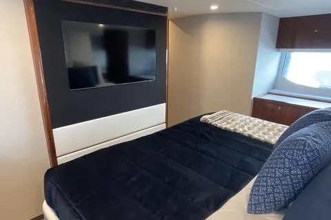 Slide: The Image of 2025 Riviera 585 SUV yacht bedroom with TV and modern decor. - 28
