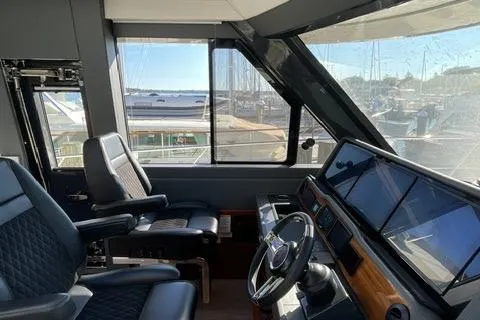 Slide: The Image of 2025 Riviera 585 SUV yacht cockpit with modern controls and panoramic marina view. - 3