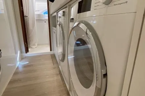 Slide: The Image of Laundry area inside 2025 Riviera 585 SUV yacht, featuring modern appliances and sleek design. - 32