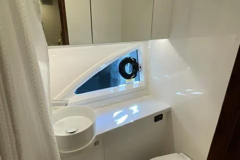 Slide: The Image of 2025 Riviera 585 SUV bathroom with modern sink and porthole window. - 33