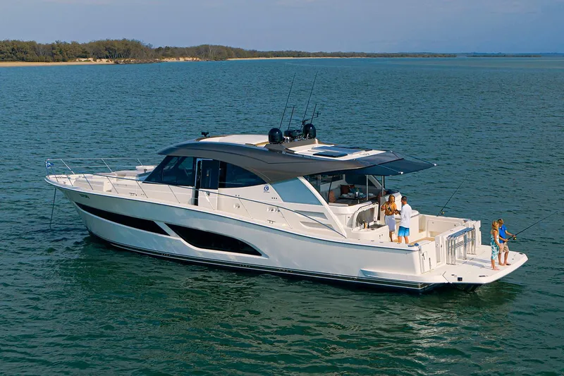 Slide: The Image of Manufacturer Provided Image: 2025 Riviera 585 SUV yacht cruising on serene waters with people on deck. - 35