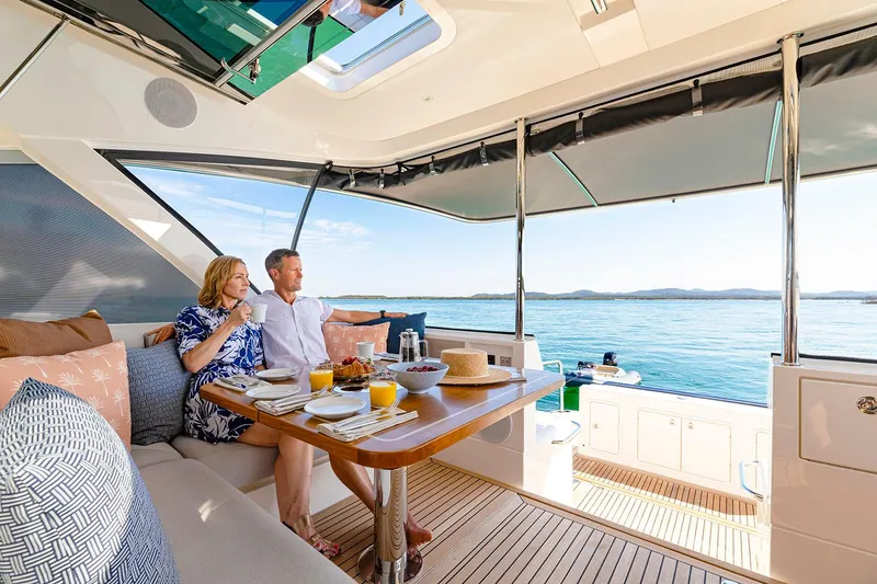 Slide: The Image of Manufacturer Provided Image: Couple enjoying breakfast on 2025 Riviera 585 SUV yacht, overlooking serene ocean view. - 41