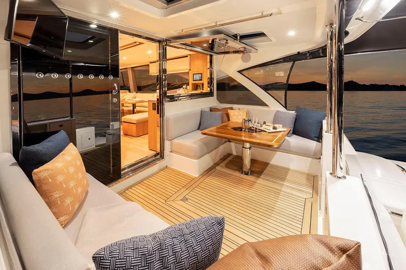 Slide: The Image of Manufacturer Provided Image: Luxurious 2025 Riviera 585 SUV yacht interior with elegant seating and dining area at sunset. - 42