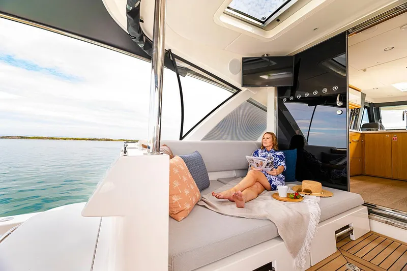 Slide: The Image of Manufacturer Provided Image: Woman relaxing on 2025 Riviera 585 SUV yacht, enjoying a serene ocean view. - 43