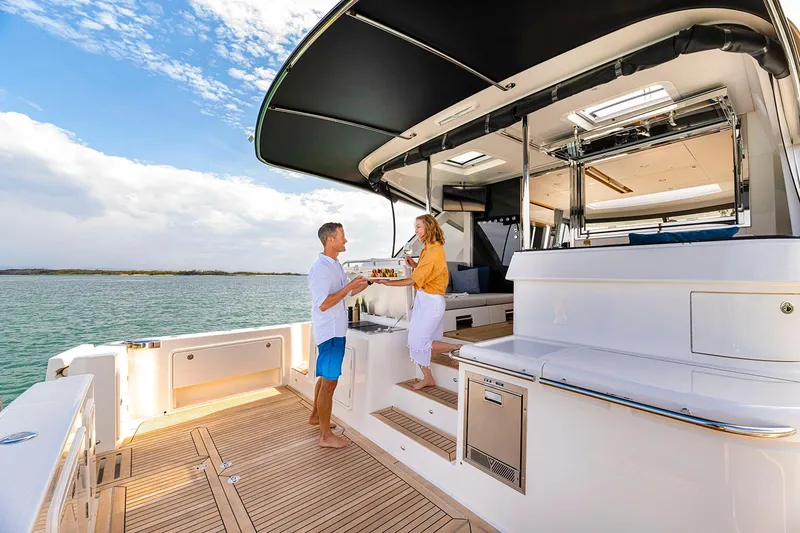 Slide: The Image of Manufacturer Provided Image: Couple enjoying leisure time on 2025 Riviera 585 SUV yacht deck. - 44