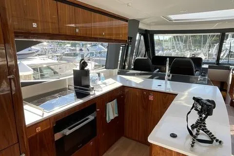 Slide: The Image of Luxurious 2025 Riviera 585 SUV yacht interior with modern kitchen and marina view. - 7