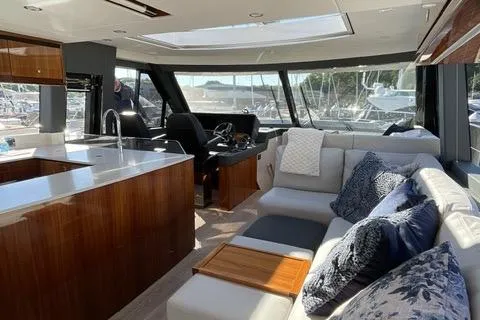 Slide: The Image of Luxurious interior of 2025 Riviera 585 SUV yacht with modern kitchen and comfortable seating. - 9
